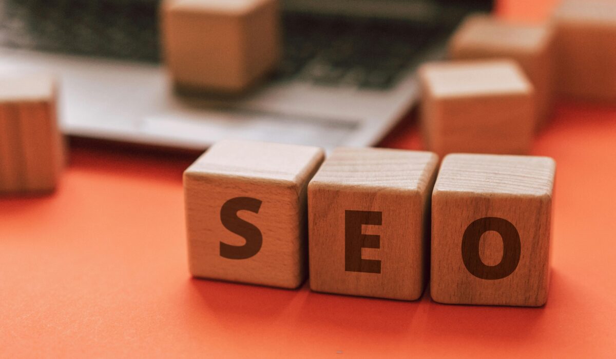 Wooden blocks spelling SEO on a laptop keyboard convey digital marketing concepts. — Photo by Atlantic Ambience on Pexels