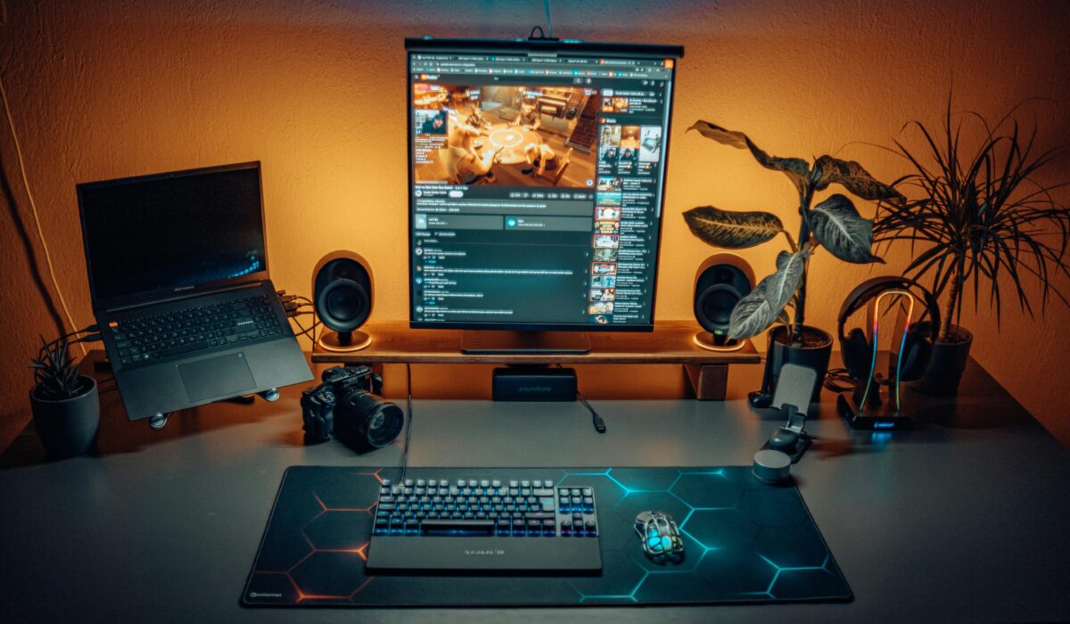 A stylish home office desk setup with laptop, screen, camera, and plants creating a modern ambiance. — Photo by Atahan Demir on Pexels